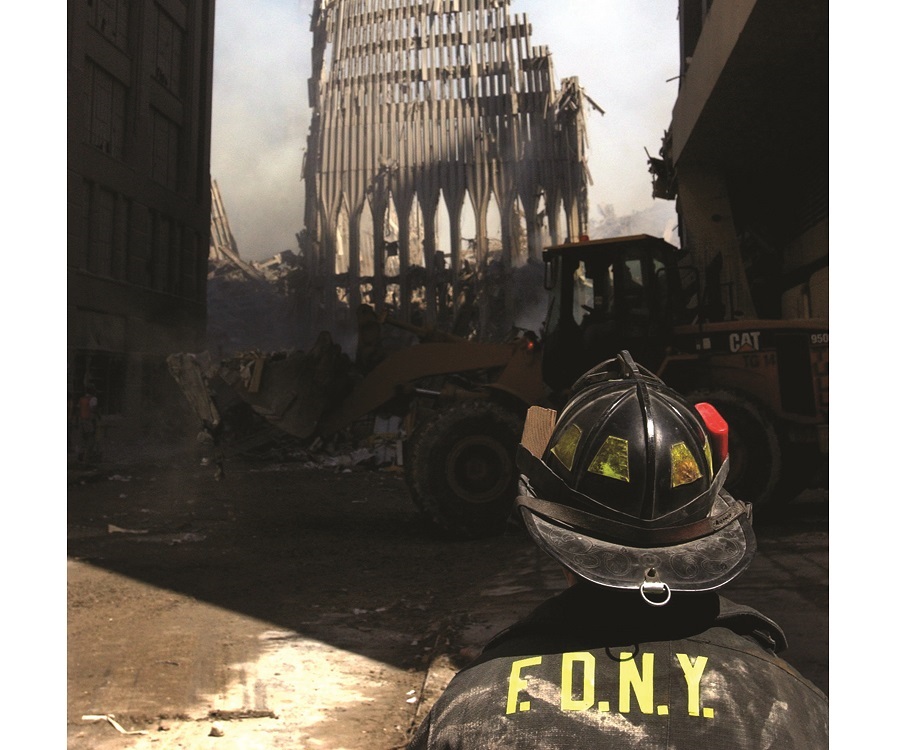 A New York City firefighter looks up at what remains of the World Trade Center after its collapse. (U.S. Navy photo by PM2 Jim Watson)