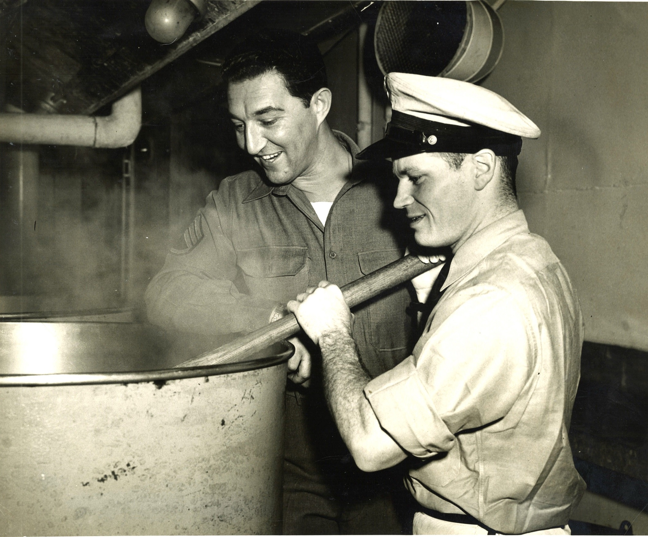 6.	Chief Commissaryman Robert Manges using an industrial-size cauldron in Wakefield’s galley with Army sergeant observing. (Courtesy of Robert Manges)