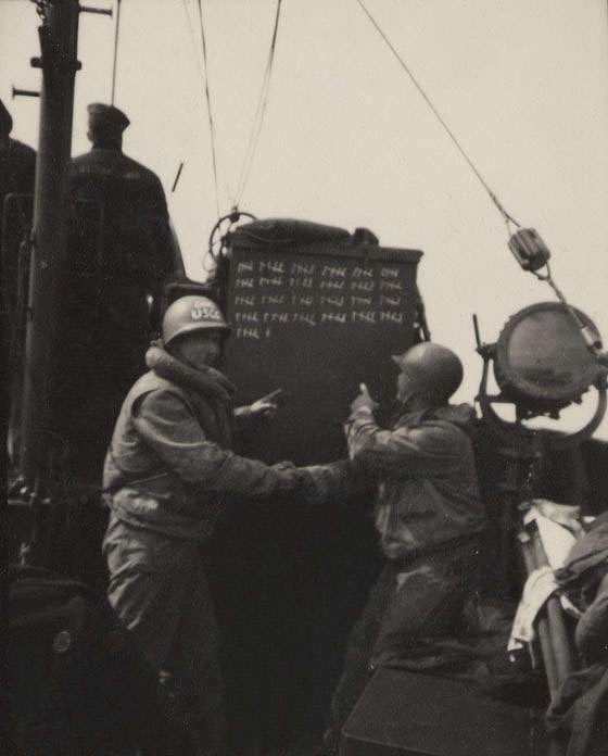 CG-16 crewmembers shake hands and point to the remarkable final tally of 126 lives saved by the cutter on D-Day. (Courtesy of Hannigan family)