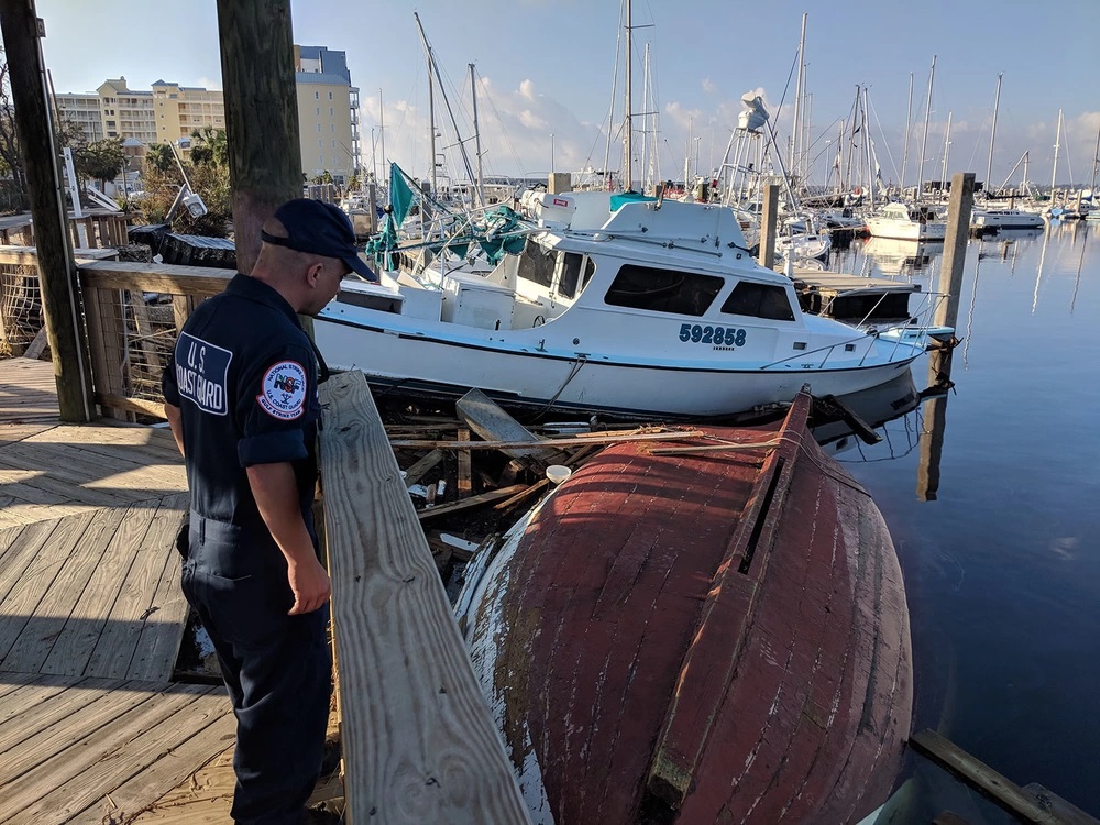 Petty Officer 1st Class Greg Dalley, a machinery technician from the Gulf Strike Team, overlooks vessels sunk and damaged by Hurricane Michael in Panama City Florida, Oct. 15, 2018. Hurricane Michael made landfall on Oct. 10, 2018, causing significant damage across North West Florida. U.S. Coast Guard photo by Chief Warrant Officer David Mueller