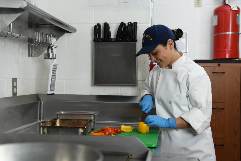 Petty Officer 3rd Class Samantha Waialae, a culinary specialist, prepares a vegetables for a stir fry in the galley of Coast Guard Station Cape Charles in Cape Charles, Virginia, March 21, 2019. Culinary specialist is one of four critical ratings for Coast Guard recruiting efforts. U.S. Coast Guard photo by Matt Sprague.