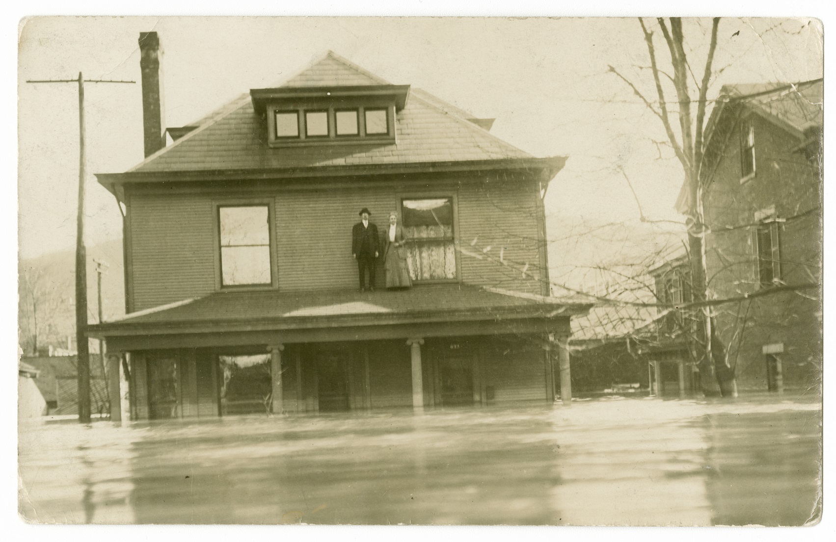 A man and wife in Dayton, Ohio, are stranded on top of their front porch during the Great Flood of 1913. (Courtesy of Wright State University)