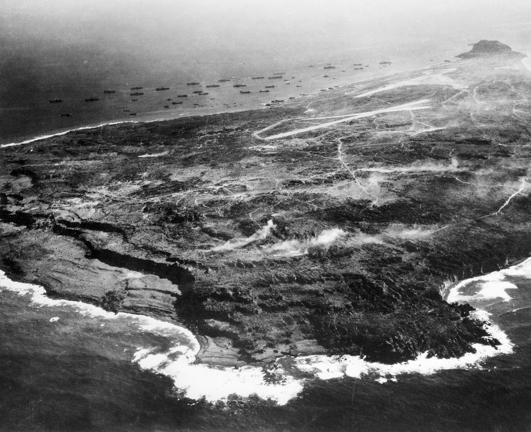 Aerial view of the eight-square mile island of Iwo Jima shows its small size. In the background are captured airfields, Mt. Suribachi and the invasion beaches. (National Archives)