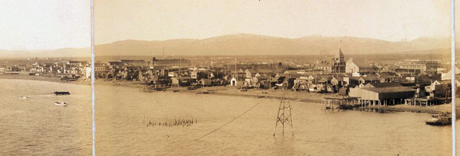 Part of a panoramic photograph of Nome, with the small white Nome Boat Station located in the center. Note the proximity of the boathouse to the open beach and the degree of exposure to high seas. (Library of Congress)