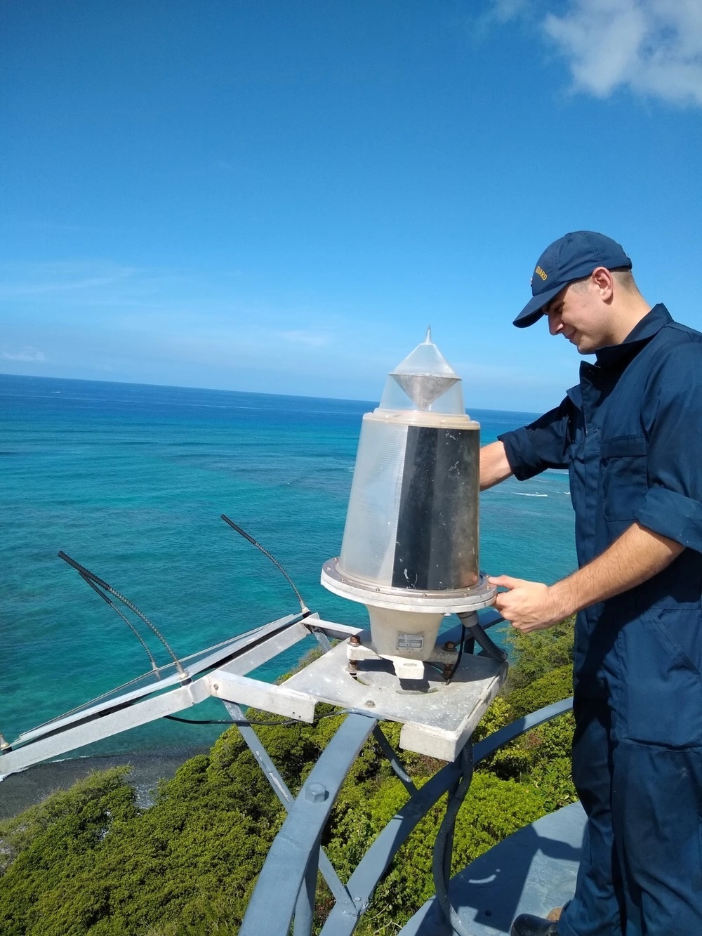 Petty Officer 3rd Class Matthew Rusich prepares to open up the Diamond Head Lighthouse's back-up lantern for maintenance. U.S. Coast Guard photo by Chief Petty Officer Joshua D. Williams.