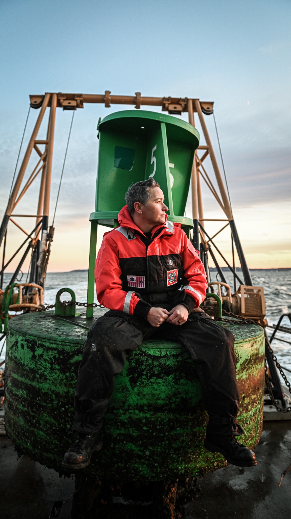 Coast Guard Chief Petty Officer Michelle Roberts, Engineering Petty Officer of Aids to Navigation Team New York, sits on top of a buoy during a transit back to homeport in Bayonne, New Jersey, November 19, 2020. Chief Roberts is the first female Native American to make the rank of Chief Petty Officer in the Coast Guard. (U.S. Coast Guard photo illustration by Petty Officer 3rd Class Anthony Pappaly) 