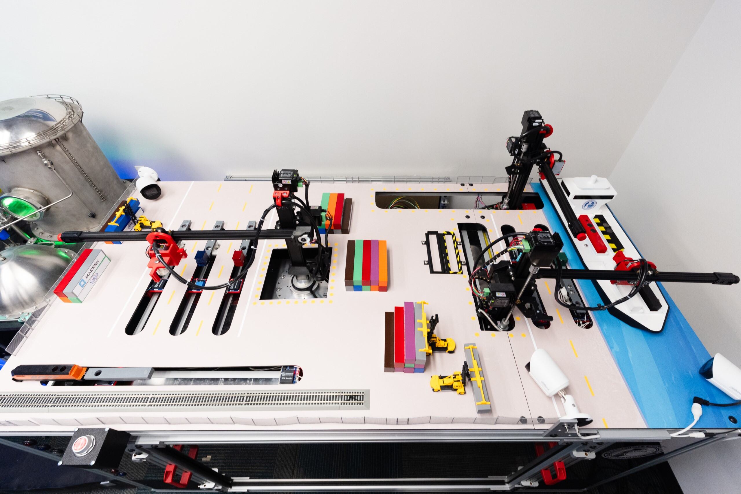 The maritime platform replicates a realistic seaport environment using miniature cranes, cargo ships, and trucks to simulate the flow of port operations. The maritime platform replicates a realistic seaport environment using miniature cranes, cargo ships, and trucks to simulate the flow of port operations.