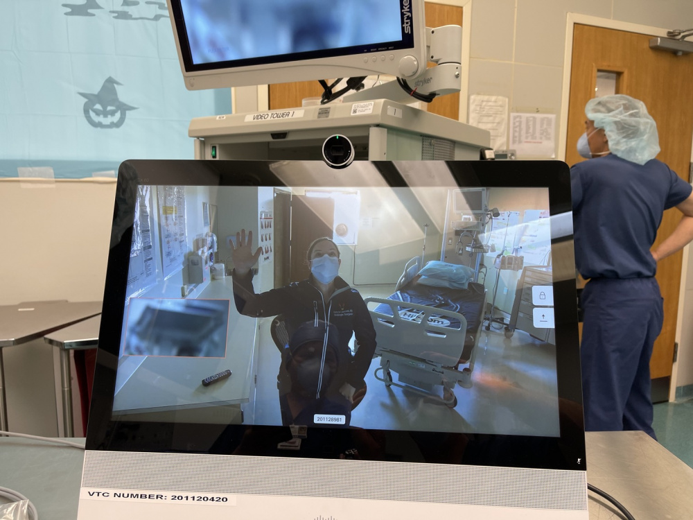 Lt. Cdr. Kathryn Lipscomb, the Urology department head at USNH Rota, Spain, waves to staff in USNH Naples, Italy during the first virtual cystoscopy between both hospitals, Jan 22, 2021. (U.S. Navy Photo by Cmdr. Ryan Nations).