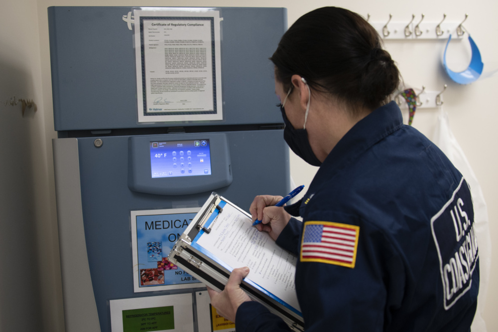 BRISTOW, Okla. - Petty Officer 1st Class Julie Bosman, assigned to the Coast Guard Atlantic Strike Team, assesses a refrigeration unit at a vaccine distribution site in Bristow, Oklahoma, Feb. 11, 2021. The Coast Guard's National Strike Force teams deployed to Oklahoma in support of efforts organized by the Federal Emergency Management Agency, Department of Health and Human Services, and state, territorial, tribal health officials, that support national goals for COVID-19 health and safety and vaccine distribution. U.S. Coast Guard photo by Petty Officer 1st Class Jetta Disco.