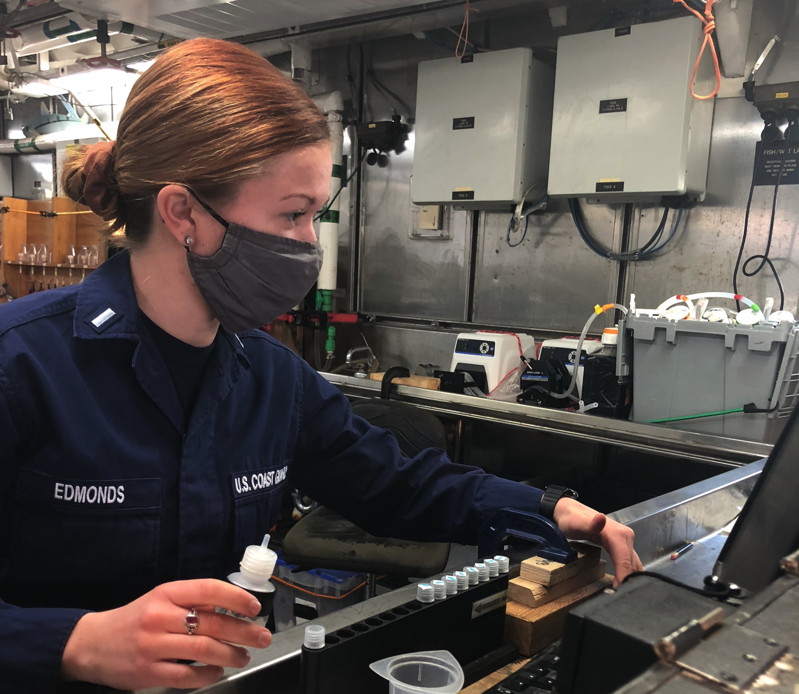 U.S. Coast Guard officer Lt.j.g. Rebecca Edmonds uses a fluorometer aboard NOAA Ship Reuben Lasker to test the water samples for chlorophyll.