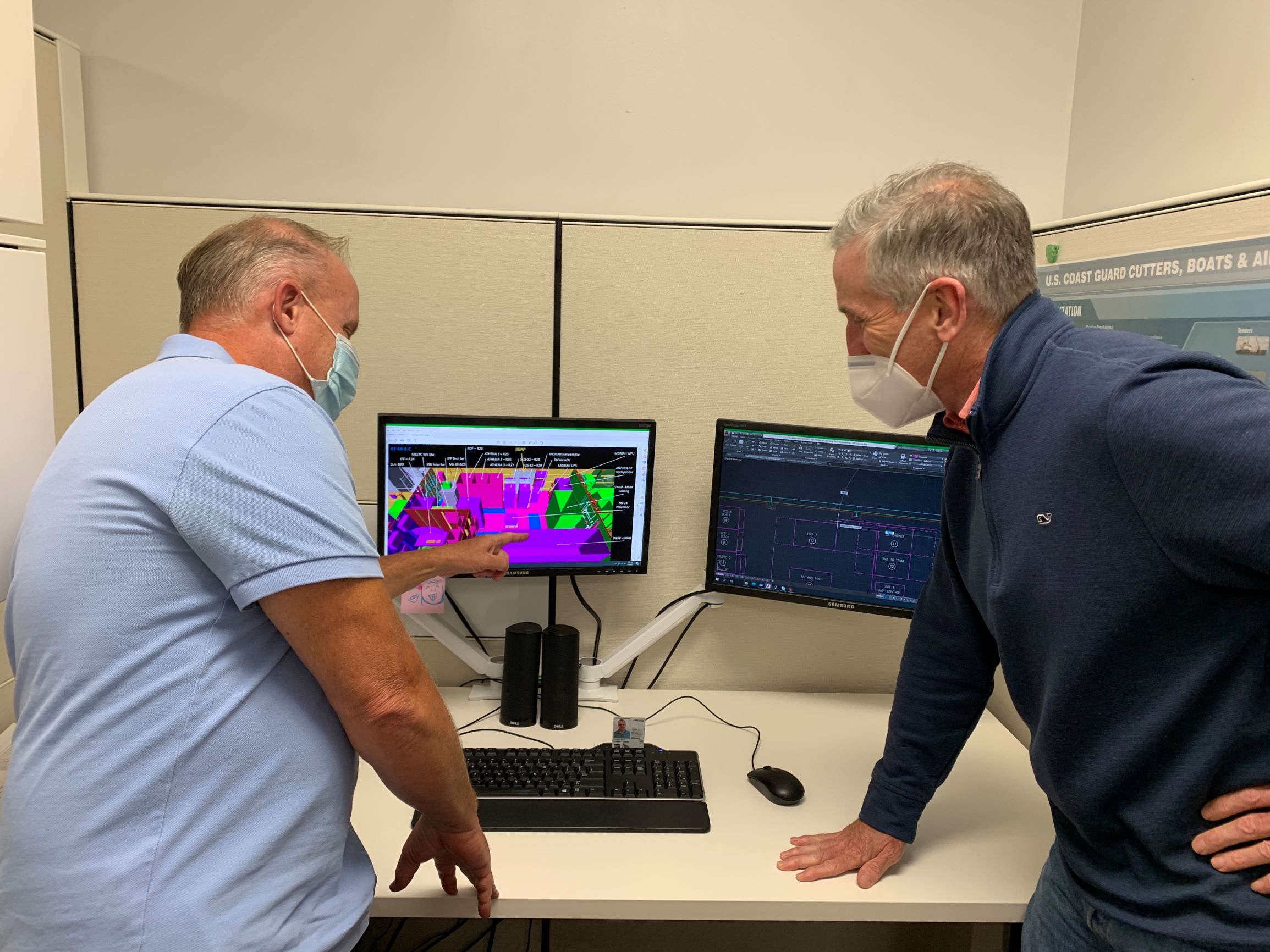 Eric Linton, Coast Guard Yard Chief of Engineering, and Bob Tenetylo, Coast Guard Yard Electrical Engineer, review and discuss the radio room arrangement for the Offshore Patrol Cutter (OPC) post delivery availability.