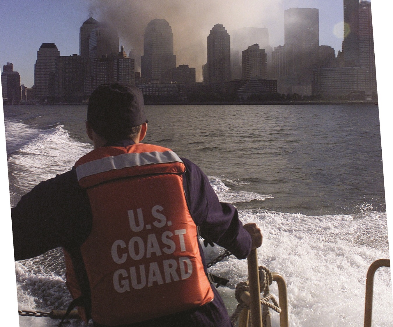 Deployed Coast Guard rigid-hull inflatable boat with World Trade Center burning in background. (U.S. Coast Guard)