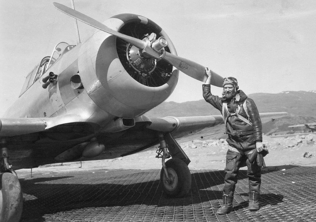 2.	Radioman First Class Benjamin Bottoms in flight gear posed in front of a military trainer aircraft. (Family of Olga Bottoms Richardson)