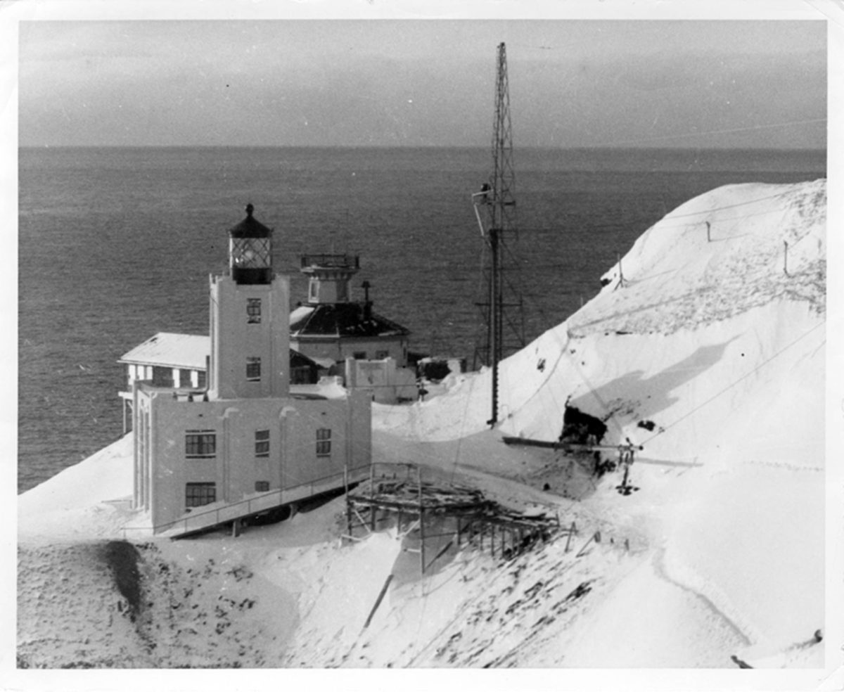 2.	Winter-time photograph showing the old Scotch Cap Lighthouse located behind the new concrete lighthouse built in 1940. (U.S. Coast Guard)