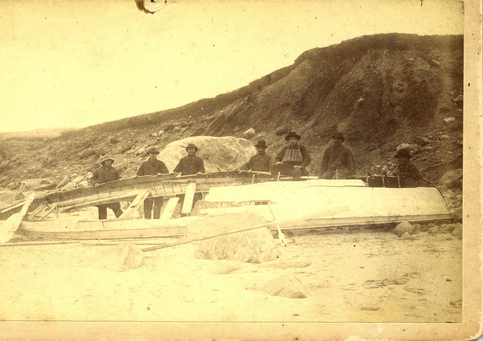 Aquinnah Wampanoag men stand with the demolished surfboat that had been launched into the breakers during the City of Columbus rescue (Courtesy of the Martha’s Vineyard Museum)