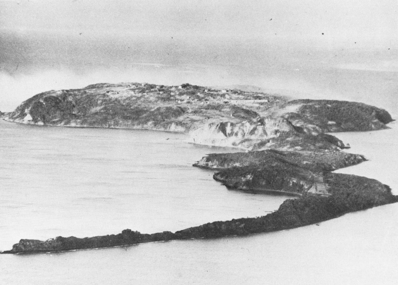 An aerial photograph of the rocky island of Corregidor, home to the underground headquarters of Fort Mills. This view from the east shows the narrow peninsula on which Japanese invasion forces landed. (U.S. Army photograph)