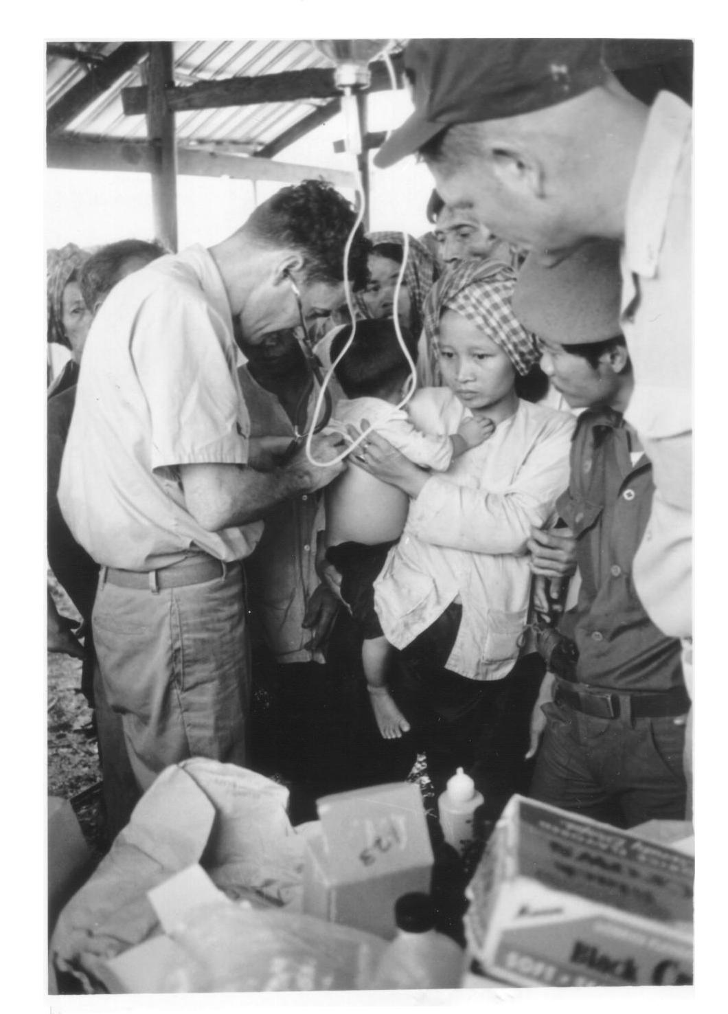 Chief Joe White providing medical care to local Vietnamese and their children during a visit to a village in South Vietnam. (Mrs. Misa White)