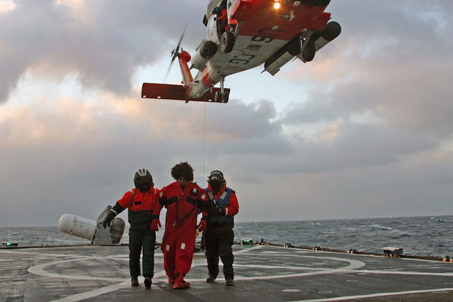 The St. Paul Island-based HH-60 Jayhawk deposits Alaska Ranger survivors on the flight deck of the high-endurance cutter Munro. (Ensign Daniel Schrader, U.S. Coast Guard)