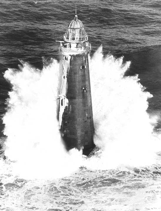 The second lighthouse structure, completed in 1860, bearing up under a winter storm. (U.S. Coast Guard)
