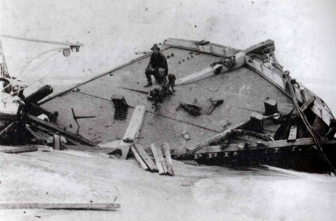 4. Photo of Surfman Rasmus Midgett seated on the beached bow section of the Priscilla after the hurricane had passed. (National Park Service) 4. Photo of Surfman Rasmus Midgett seated on the beached bow section of the Priscilla after the hurricane had passed. (National Park Service)