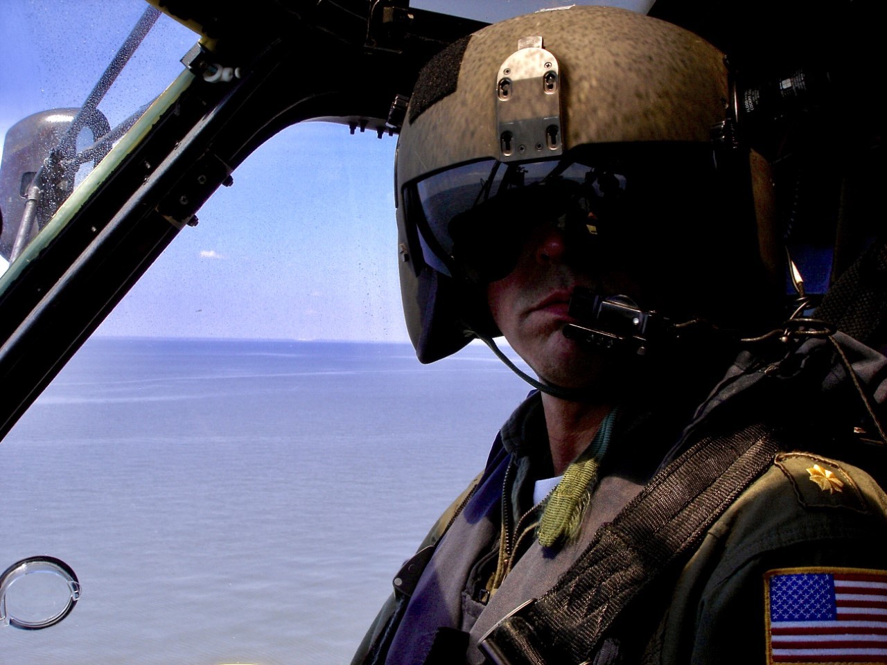 Lt. Cmdr. Jim O’Keefe in the co-pilot seat of a Coast Guard helicopter during flight operations over water. (Photograph courtesy of James O’Keefe)