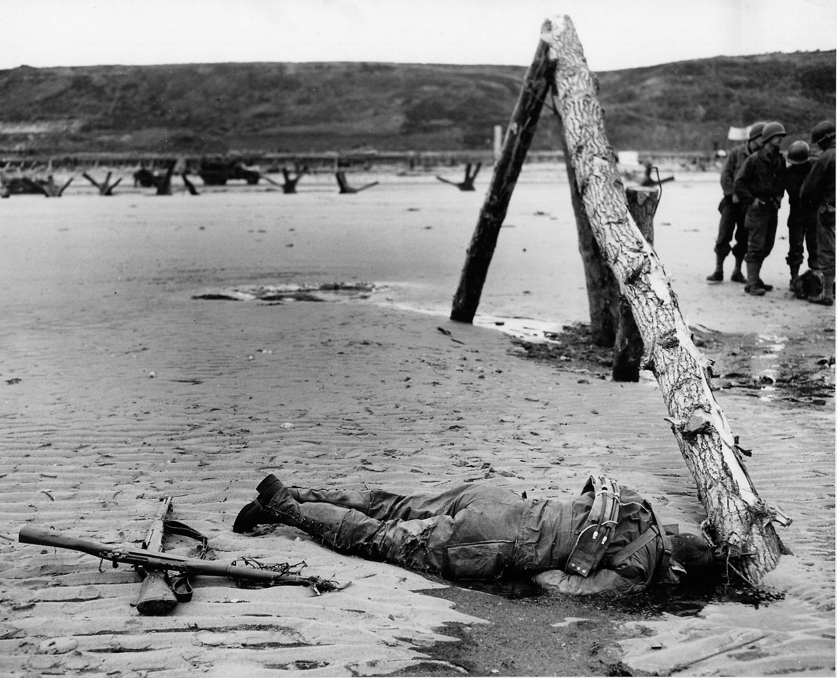 Photographed after the capture of Omaha Beach, this image shows one a “Rommel’s Asparagus” at low tide. (U.S. Coast Guard)