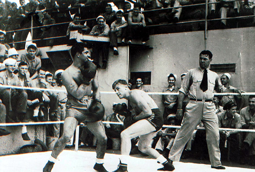 Photo showing heavyweight boxer and Coast Guard officer, Jack Dempsey, refereeing a boxing match on board the Wakefield. (U.S. Coast Guard)