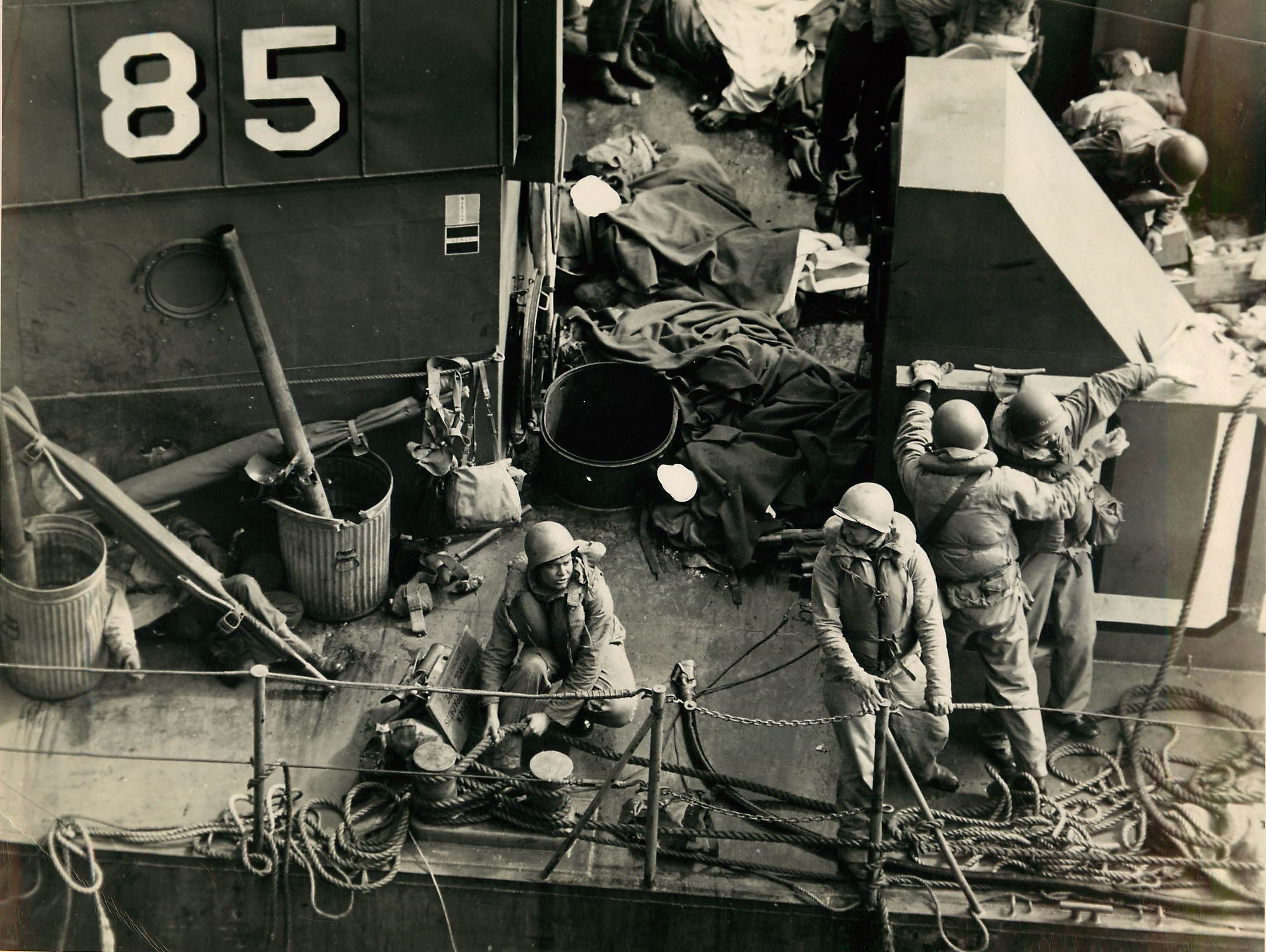 The dead lay on deck while the living struggle to save LCI-85 from sinking. (U.S. Coast Guard)