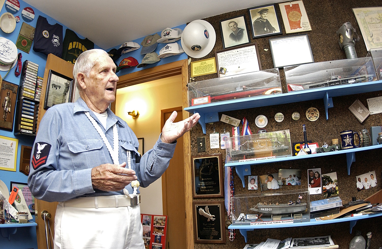 A photograph of Marin Perrett displaying his collection of mementos and memorabilia at his home. (U.S. Coast Guard photo by Petty Officer 3rd Class NyxoLyno Cangemi)