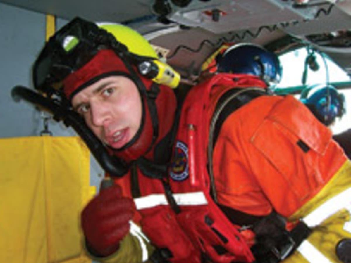 Rescue swimmer, Petty Officer 3rd Class Abram Heller, in dry suit aboard a Coast Guard rescue helicopter. (U.S. Coast Guard)