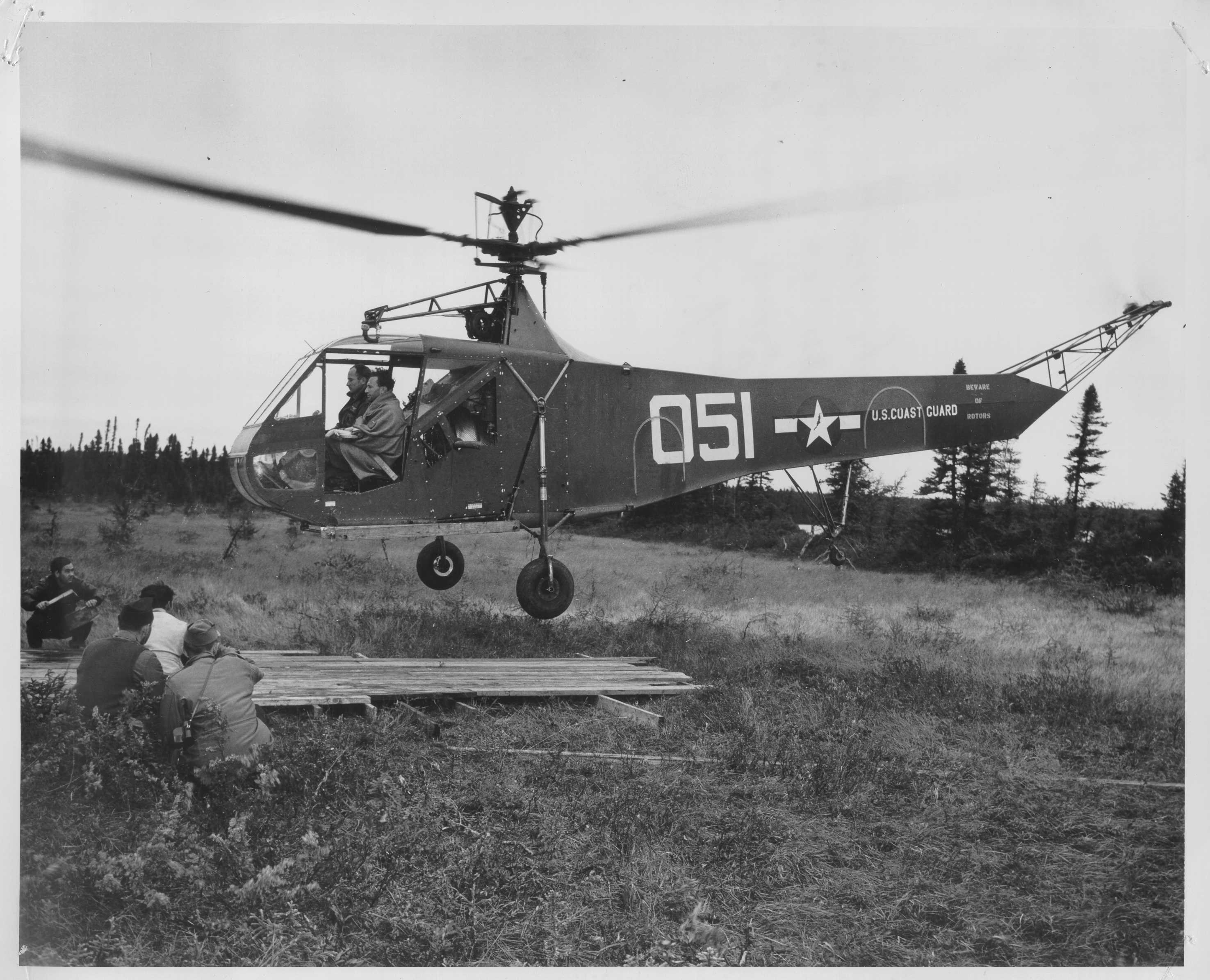 A Coast Guard Sikorsky HNS-1 “Hoverfly” landing on a makeshift landing pad placed on the soft muskeg near the crash site. (U.S. Coast Guard)
