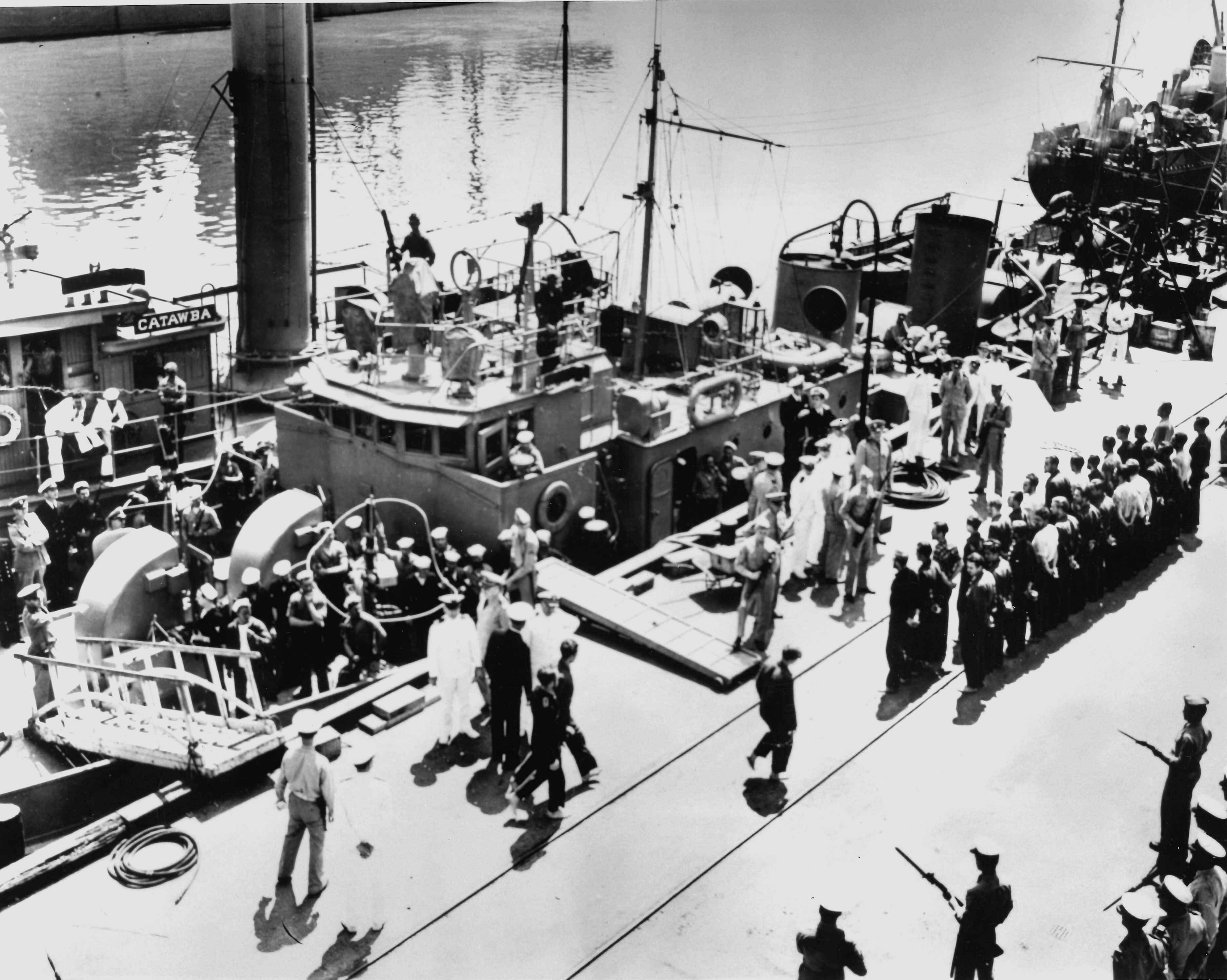 First German POWs captured by U.S. forces are marched off Cutter Icarus onto the docks at the former Charleston Navy Yard, now Coast Guard Base Charleston. The cutter sank their submarine, U-352, in May 1942 off the North Carolina coast. (U.S. Coast Guard)