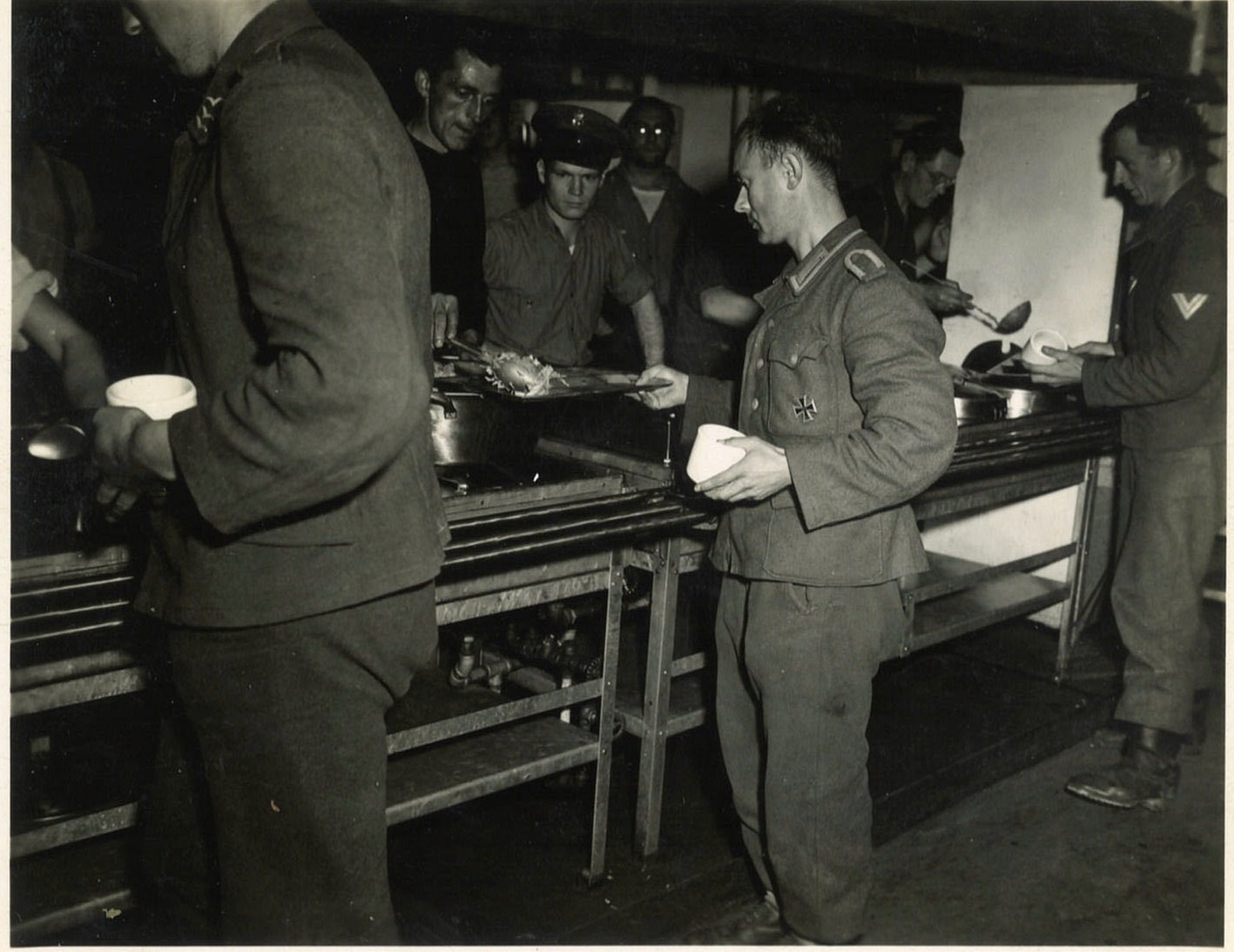 8.	Chief Commissaryman Robert Manges serving German POWs still wearing uniforms from before their capture in Normandy by the Allies. (Courtesy of Robert Manges)