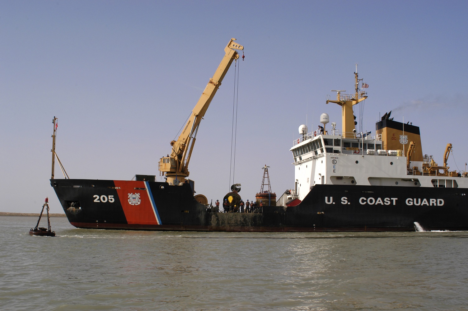 Ocean-going buoy tender Coast Guard Cutter Walnut performing aids-to-navigation work along the ship channel of the Khor Abd Allah Waterway. (U.S. Coast Guard)