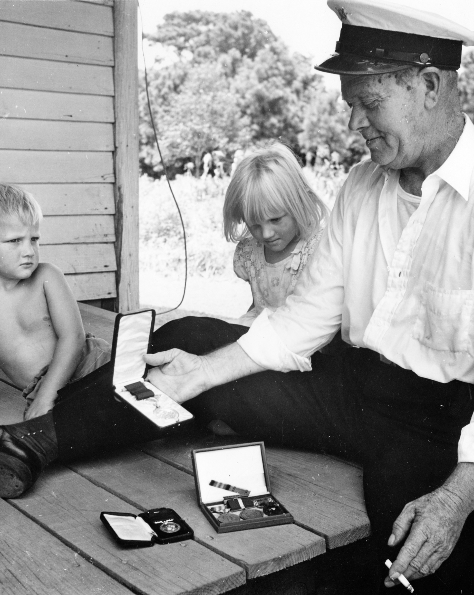 Leroy Midgett showing his lifesaving medals to young Midgett family members. (Courtesy of the Outer Banks History Center)