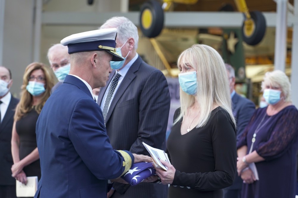 Admiral Charles Ray, the Vice Commandant of the U.S. Coast Guard, presents the mother of Lt.j.g. Morgan Garrett a folded American flag at her daughter's memorial service at the National Naval Aviation Museum in Pensacola, Florida, Wednesday, Nov. 4, 2020. 
