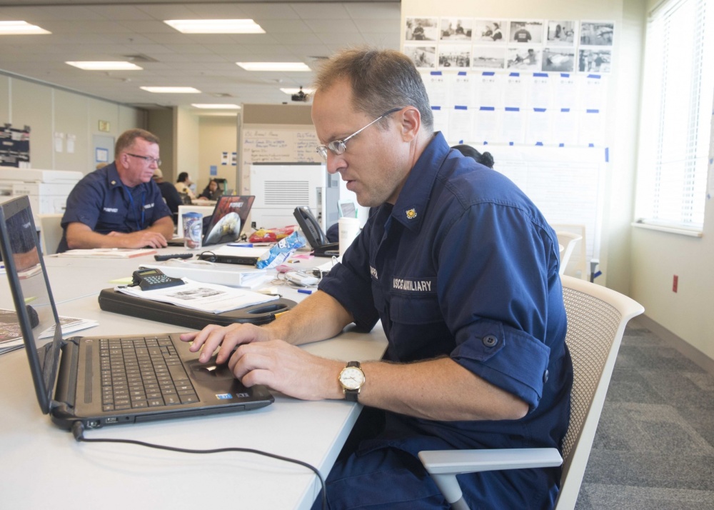 Auxiliarist Michael Kappas, foreground, and Auxiliarist Rusty Pumphrey, who are among about 60 Coast Guard Auxiliarists activated for service during Hurricane Harvey and its aftermath, work in the Houston incident command post Sept. 17, 2017. Both are contributing to an EPA-led oil and hazardous material recovery effort drawing on expertise from federal, state, local, and tribal partners. U.S. Coast Guard photo by Chief Petty Officer John Masson.