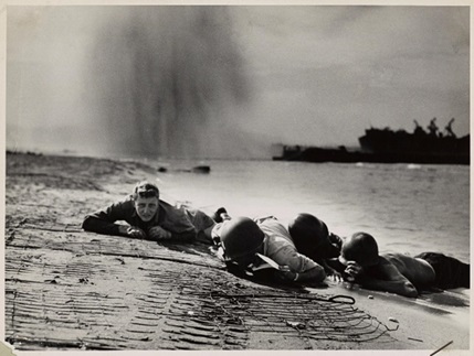 4.	Down the ramp of a Coast Guard landing barge Yankee soldiers storm toward the beach-sweeping fire of Nazi defenders in the D-Day invasion of the French Coast. Troops ahead may be seen lying flat under the deadly machinegun resistance of the Germans. Soon the Nazis were driven back under the overwhelming invasion forces thrown in from Coast Guard and Navy amphibious craft. (NARA)