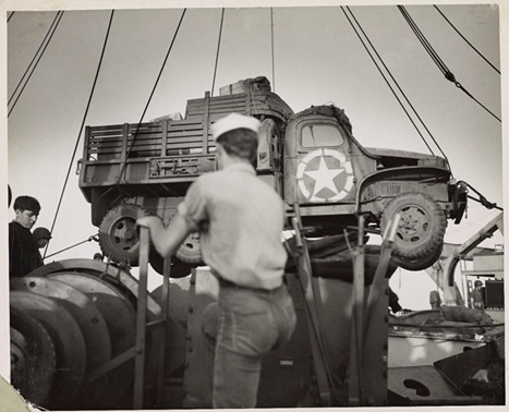 3.	Coast Guardsmen swing an Army truck overside as their combat transport lies off a bridgehead established by the Americans as Paesternum, just south of Salerno. Coast Guardsmen waiting in a landing barge alongside the transport will take the truck ashore. (NARA)